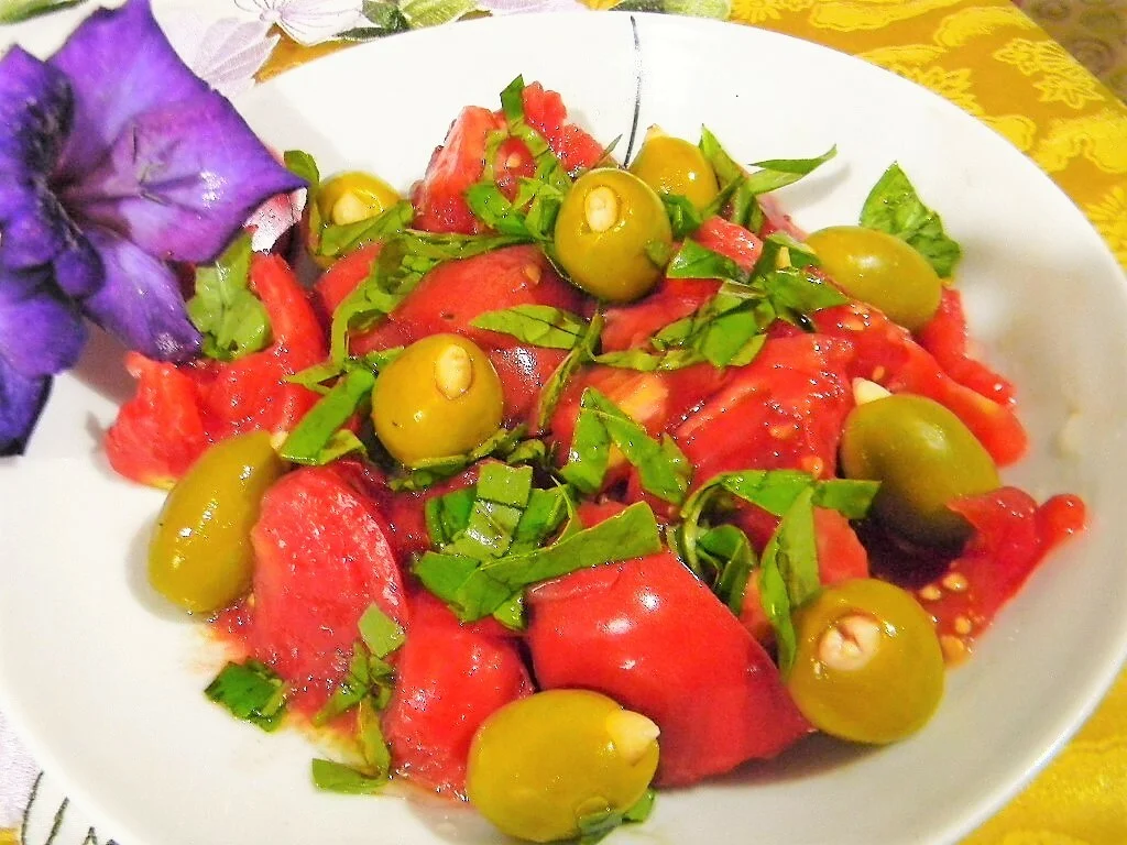 Tomato salad with stuffed olives and basil