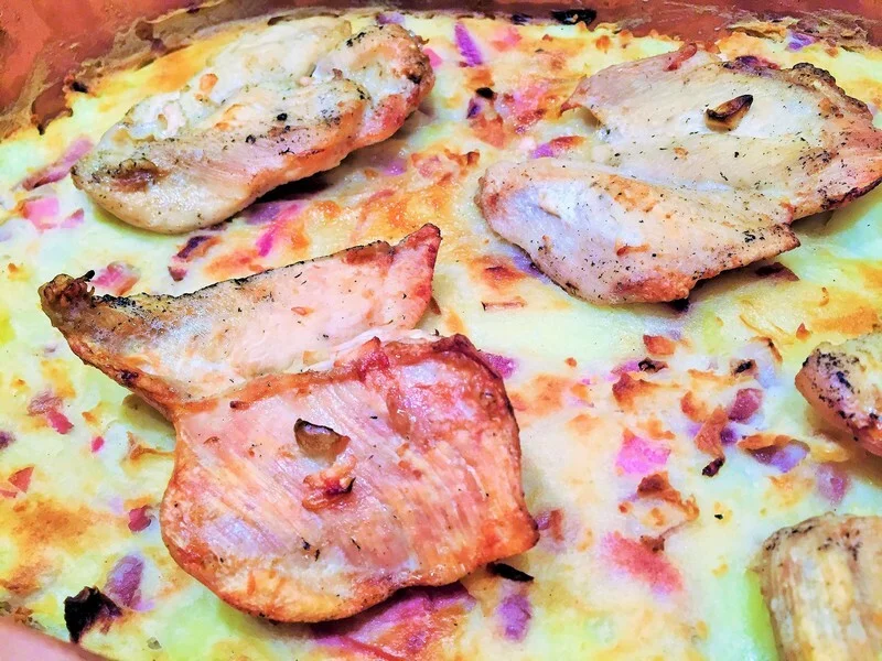 Rustic mashed potatoes in a clay pot with chicken and garlic