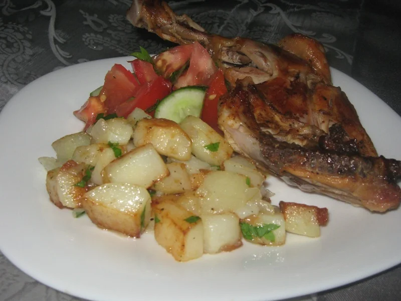 Fried chicken thighs with a side of potatoes and salad
