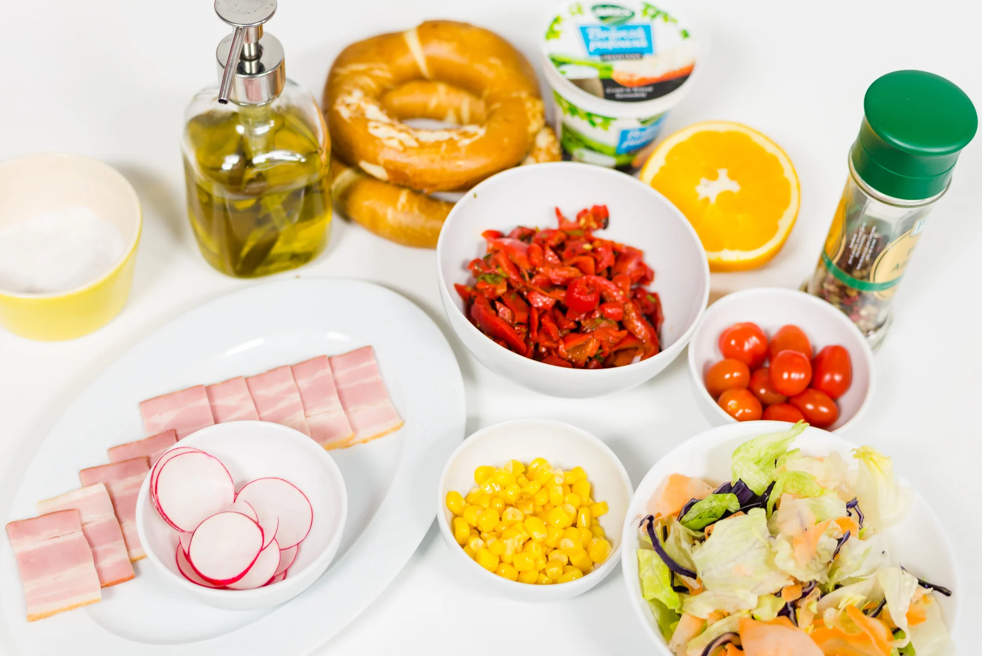 Bagel with Delaco cream cheese with sour cream, bacon, and roasted pepper salad