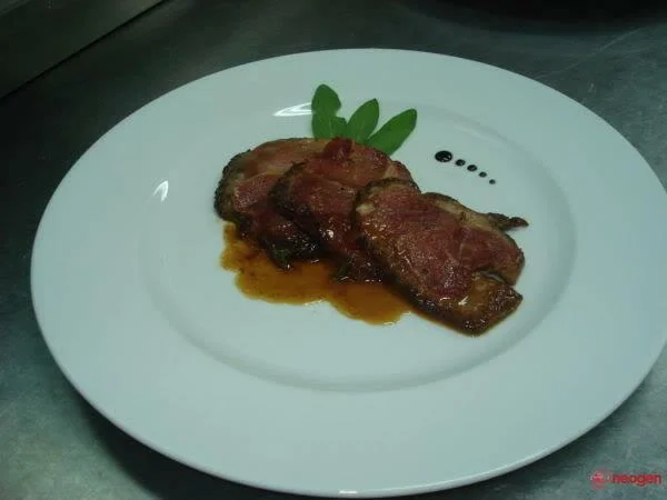 Slices of beef tenderloin with prosciutto and sage leaves.