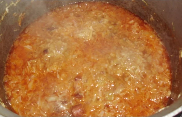 Braised cabbage with smoked meats in a pot in the oven