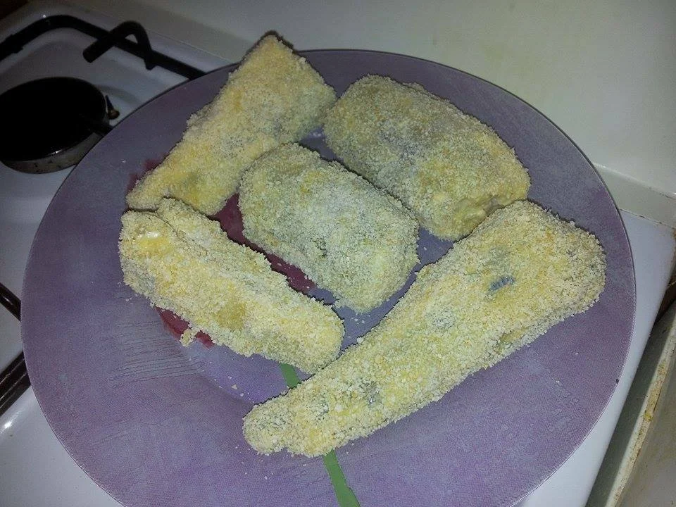 Over breaded hake in a pan