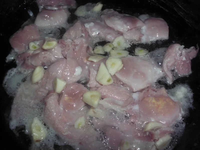 Raw bacon cooked in a pan