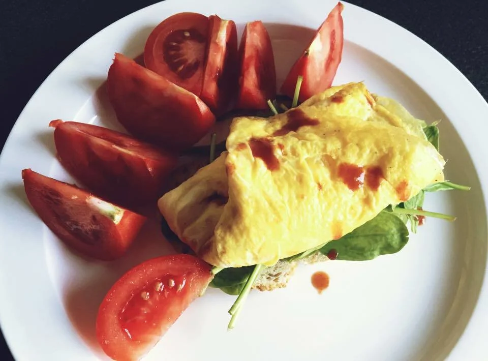 Fluffy omelette with spinach, tomatoes, and Parmesan