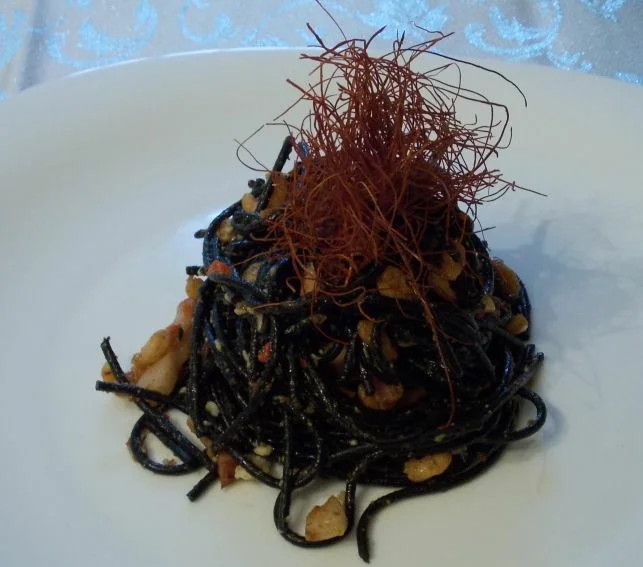 Spaghetti with cuttlefish ink, shrimp, and bacon