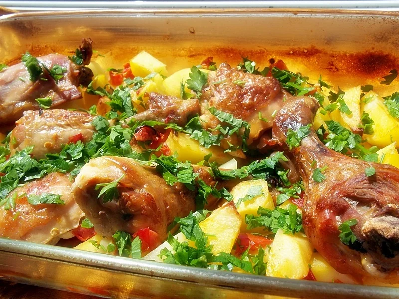 Chicken thighs with potatoes and tomatoes baked