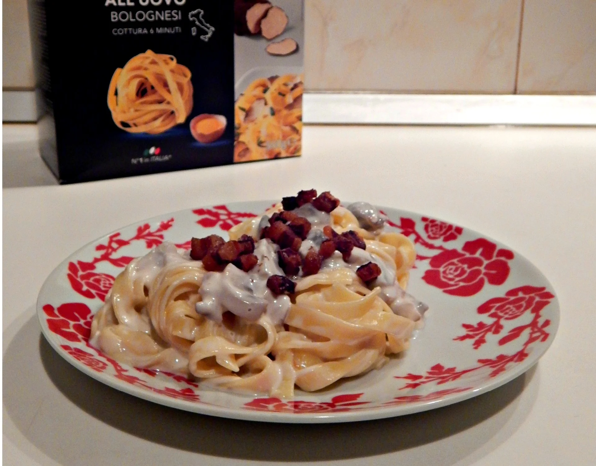 Tagliatelle with cheese sauce, mushrooms, and bacon bits