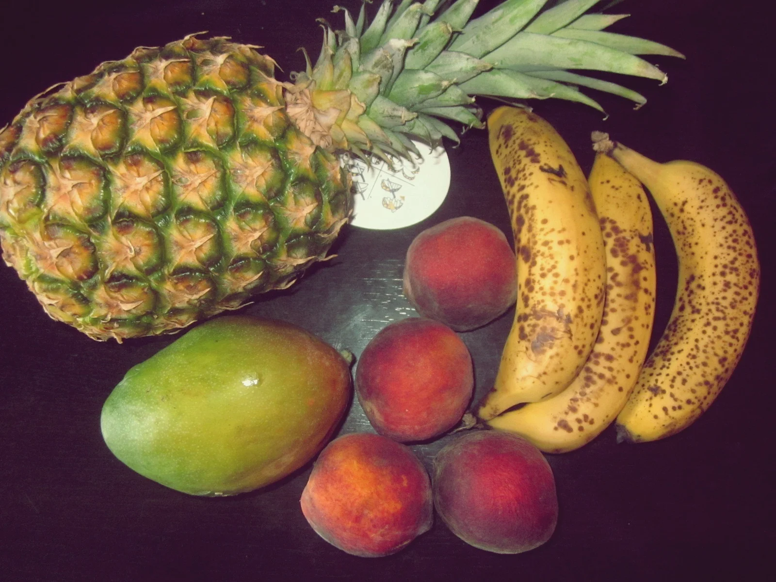 Fresh peaches, mangoes, bananas, and pineapples