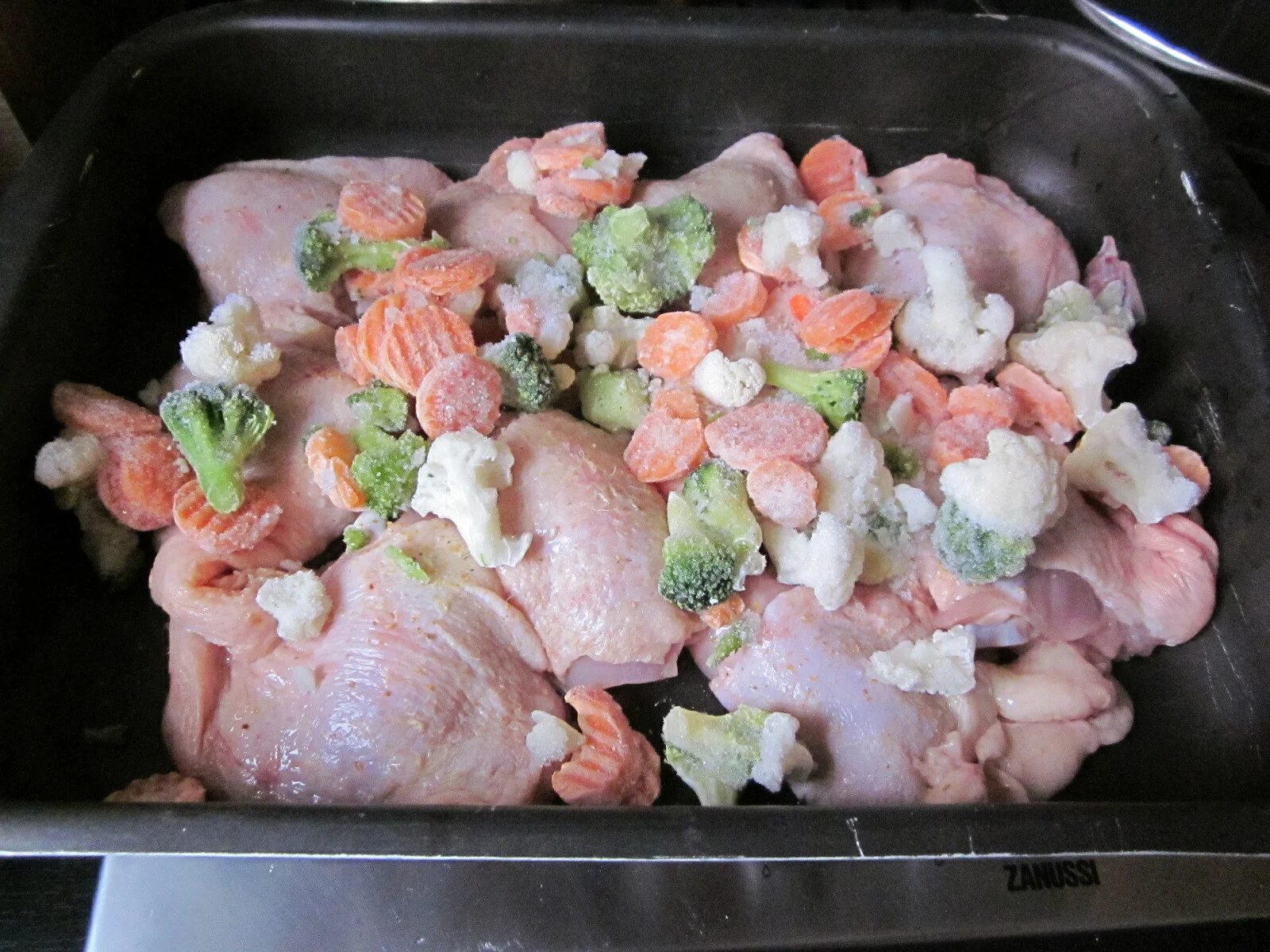 Boneless chicken thighs with rice and oven-baked vegetables